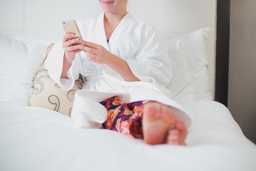 woman-relaxes-on-hotel-bed_925x